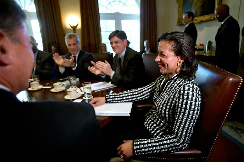United Nations Ambassador Susan Rice (right) smiles as she is applauded as President Barack Obama recognizes her job performance before meeting with his Cabinet on Wednesday in the Cabinet Room of the White House in Washington. 