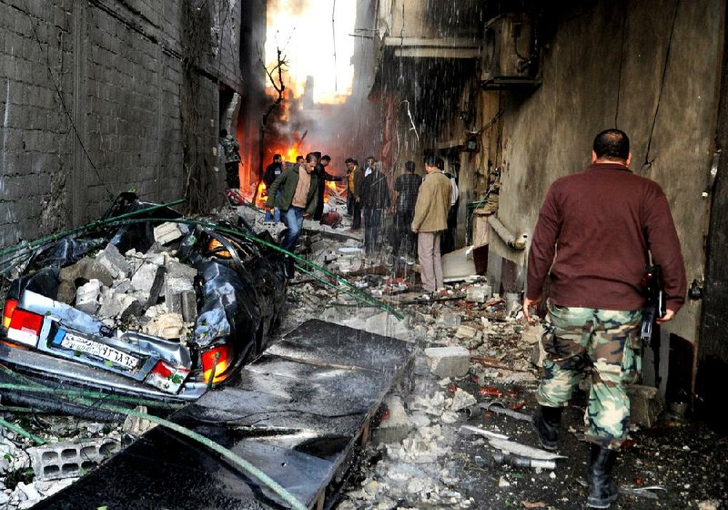 Debris fills an alley Wednesday in suburban Damascus after two car bombs exploded near commercial buildings as many people were arriving for work.


