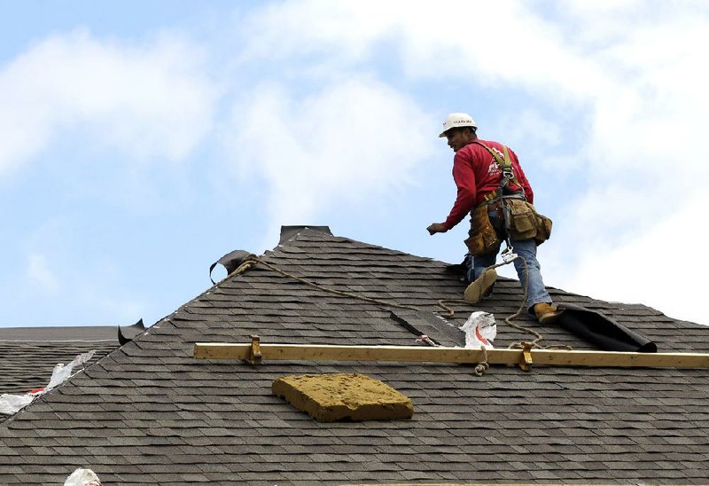 A construction worker finishes a roof in Chicago in October. The Commerce Department said Wednesday that new-home sales dipped 0.3 percent during the month. 