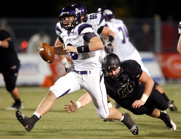 Justin Fair, a Bentonville senior defensive lineman, dives to attempt to tackle Fayetteville senior quarterback Austin Allen on Nov. 2 at Tiger Stadium in Bentonville.