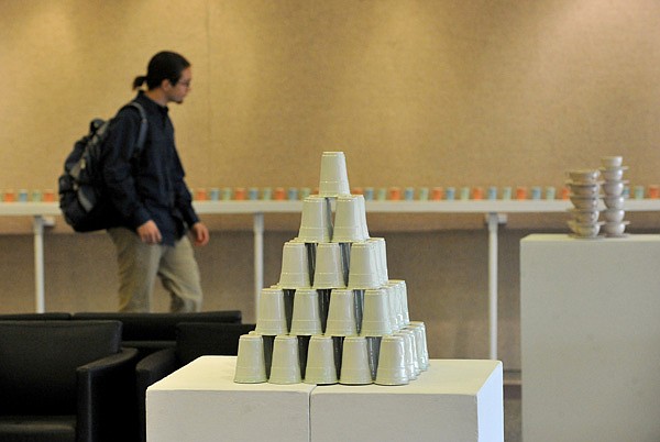 A University of Arkansas student checks out Kelly Brenner Justice’s Solo Show exhibition at the Anne Kittrell Art Gallery on the Fayetteville campus Thursday. The exhibit, which includes art made from plastic dinnerware ranging from vintage melmac and melamine to 1950s Tupperware to modern Solo products, will be on display until Jan. 31. 