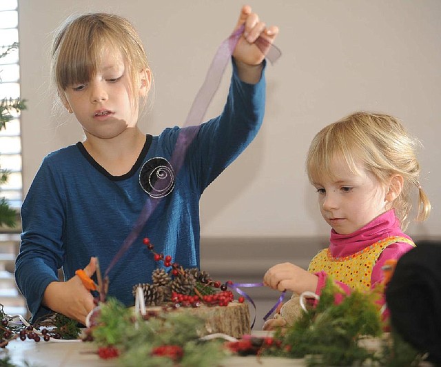 Miranda Shaver, 8, left, and her 5-year-old sister Naomi make an Advent wreath Nov. 25 at St. Paul’s Episcopal Church in Fayetteville. The wreaths are a way to mark the four Sundays of Advent and feature three purple candles and one rose-colored candle. 