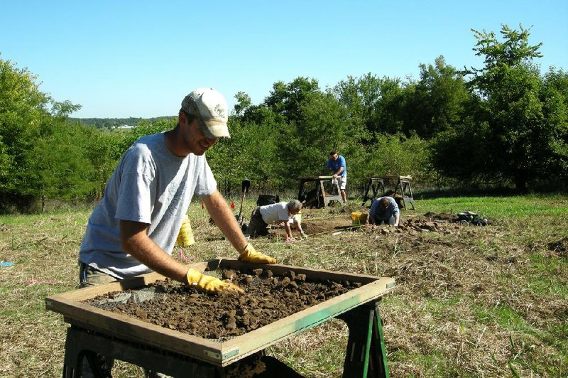 Devin Pettigrew of Fayetteville, a student at the University of Arkansas, sifts through material unearthed during a dig at Prairie Grove Battlefield State Park in Washington County last year. Archaeologists have recently determined the locations of several houses, a post office and a road involved in the Battle of Prairie Grove. 