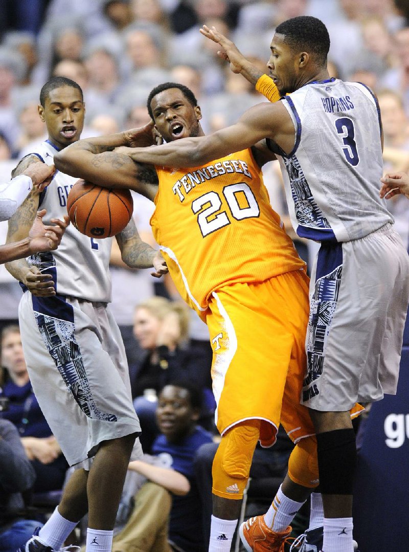 Georgetown forward Mikael Hopkins (3) and Greg Whittington (left) battle for the ball against Tennessee forward Kenny Hall (20) during Friday’s game in Washington. Georgetown won, 37-36. 