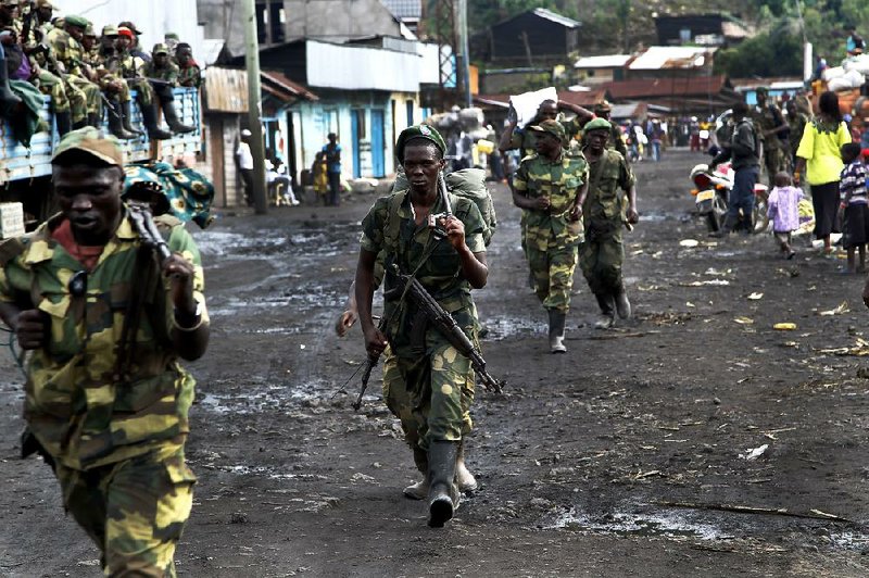 M23 rebels withdraw from the eastern Congo town of Sake on Friday. The fighters said they will leave Goma on Sunday. 