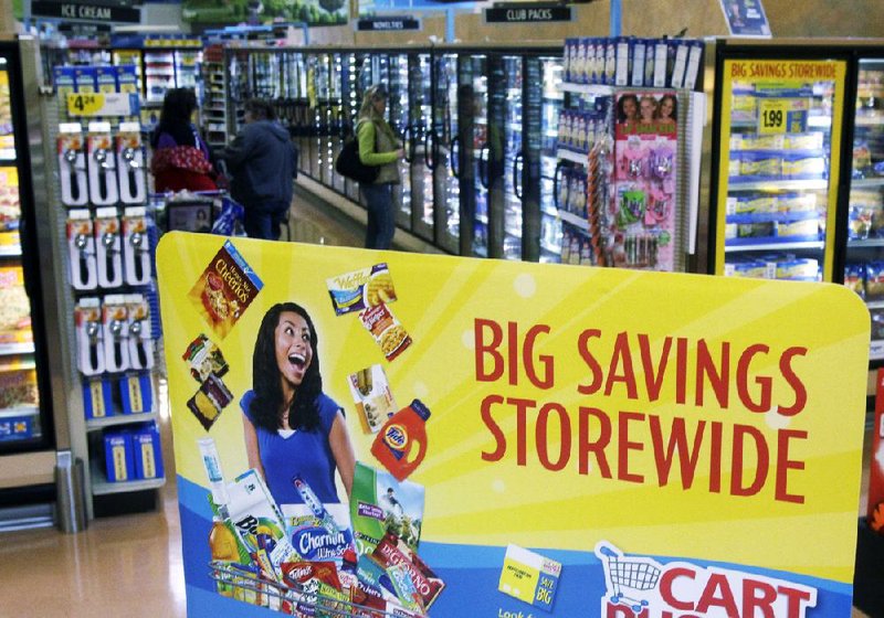 Customers shop in the frozen food section of a Kroger supermarket, in Cincinnati. On Thursday, Kroger Co. raised its earnings outlook for the year after the supermarket chain reported a thirdquarter profit that topped Wall Street expectations. 