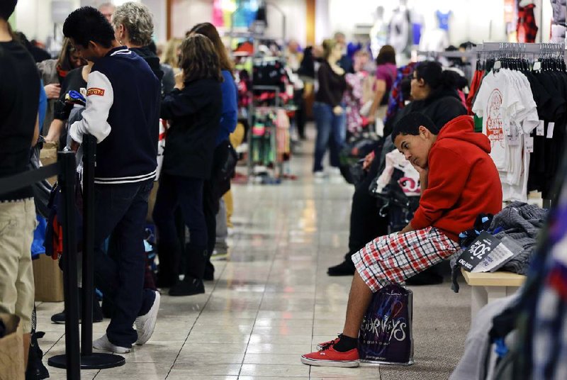 Shoppers at a J.C. Penney store in Las Vegas wait to check out on Black Friday. Retailers surveyed by the International Council of Shopping Centers reported November sales through last Saturday were up 1.7 percent compared with a year ago. 