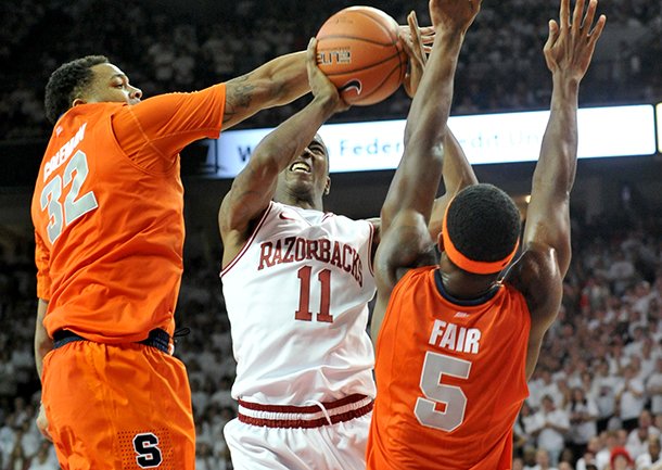 NWA Media/MICHAEL WOODS --11/30/2012-- Arkansas guard BJ Young is fouled by Syracuse defender DaJuan Coleman as he drives to the hoop during the first half of Friday night's game at Bud Walton Arena in Fayetteville. 