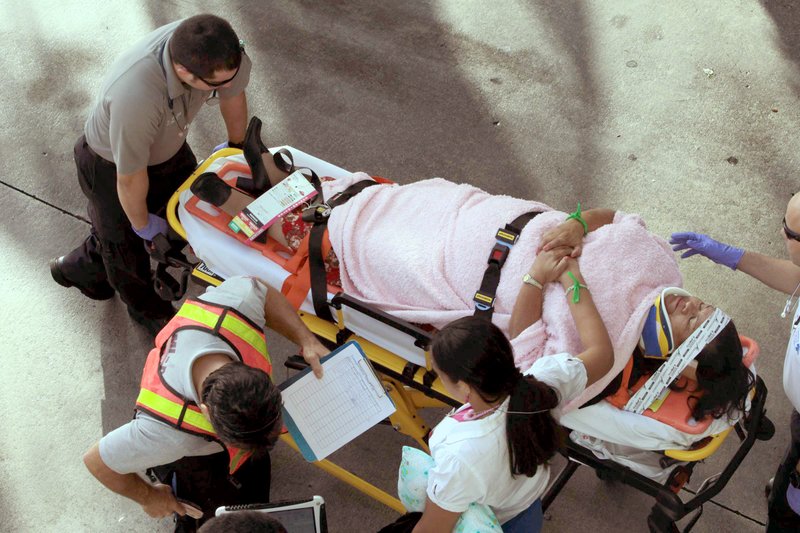 Emergency personnel attend to injured passengers after a bus accident at Miami International Airport on Saturday, Dec. 1, 2012 in Miami. Officials say a bus has hit an overpass, killing at least one person and injuring more than two-dozen people on board. Airport spokesman Greg Chin says the large, white bus hit the overpass going into the airport's arrivals section on Saturday morning. The bus was going about 20 mph when it clipped the roof entrance.