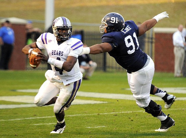 Central Arkansas quarterback Wynrick Smothers (left) escapes pressure from Georgia Southern defensive tackle Justice Ejike during UCA’s 24-16 loss in the Football Championship Subdivision playoffs Saturday in Statesboro, Ga. 