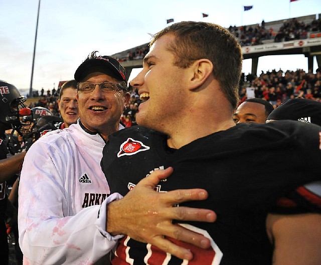 Arkansas State Coach Gus Malzahn and linebacker Nathan Herrold celebrate Saturday after a 45-0 victory over Middle Tennessee clinched ASU’s second consecutive Sun Belt Conference title. 