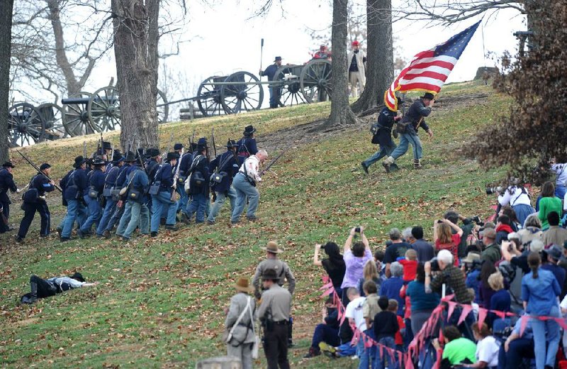 Union soldiers advance up a hill Saturday as they try to drive back Confederate troops during a Civil War re-enactment at Prairie Grove Battlefield State Park in Washington County. The re-enactment celebrated the 150th anniversary of the Battle of Prairie Grove. 