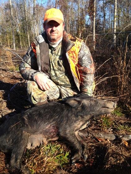Ross Romine killed this wild hog Tuesday while deer hunting in Grant County. Hogs have proliferated the area, competing with deer and turkeys for food but creating hunting opportunities. 