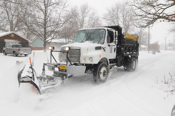 A snow plow clears a Bentonville neighborhood road Feb. 1, 2011. 