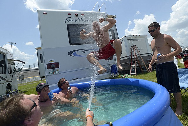 Ted Georges, of Columbus, Ohio, jumps into a pool from the top of a recreational vehicle parked in the infield at Daytona International Speedway in Florida in July. RV makers are churning out more vehicles, with shipments to dealers expected to rise 10 percent in 2012. 