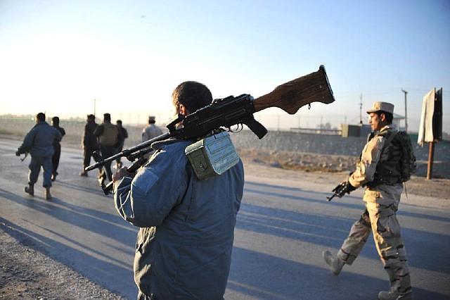 Afghan security forces patrol the site where Taliban suicide bombers attacked a joint U.S.-Afghan base Sunday in Jalalabad, Afghanistan. 