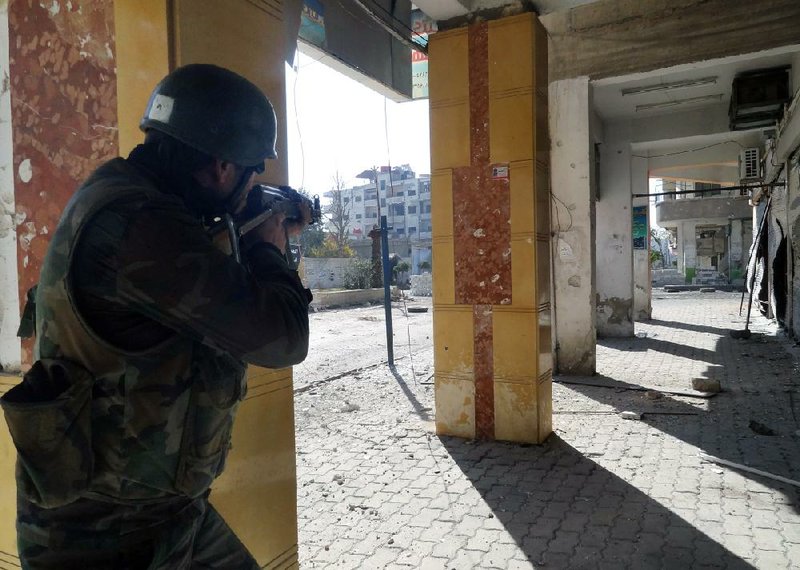 A Syrian soldier aims his rifle at free Syrian Army fighters during clashes in the Damascus suburb of Daraya on Sunday. Syrian warplanes and artillery pummeled areas in and around Damascus, Aleppo and several other cities, according to reports received by human-rights activists. 