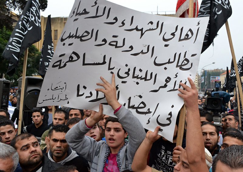 Lebanese supporters of Islamic group, hold a poster with Arabic that reads, "the parents of the martyrs and those still living, demand the republic and the Lebanese Red Cross contribute to bring our children," during a protest in the northern city of Tripoli, Lebanon, on Monday Dec. 3, 2012. 