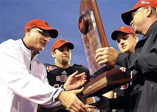 Arkansas State head coach Gus Malzahn, from left, quarterback Ryan Aplin and linebacker Nathan Herrold are presented with the Sun Belt Conference trophy following their NCAA college football game against Middle Tennessee on Saturday. Malzahn was hired as head coach at Auburn on Tuesday.