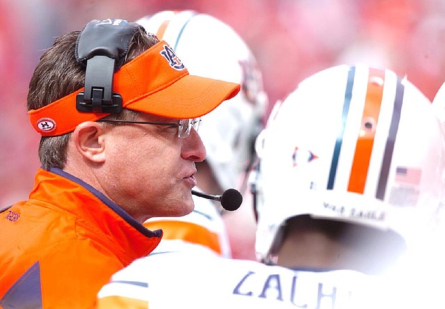 Auburn offensive coordinator Gus Malzahn talks to his players in the first quarter against Arkansas at Razorback Stadium in Fayetteville on Oct. 10, 2009. 