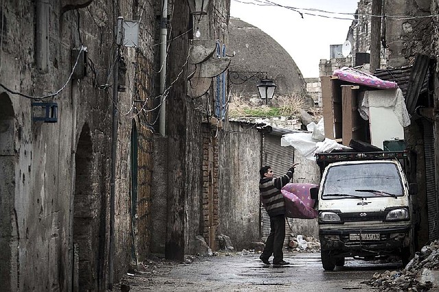 A Syrian loads his belongings on a truck Tuesday as he prepares to flee fighting between Free Syrian Army fighters and government forces in Aleppo, Syria. 