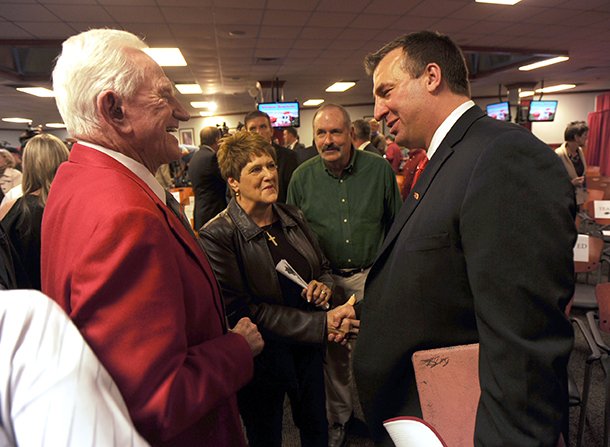 STAFF PHOTO ANDY SHUPE -- Former Arkansas athletics director Frank Broyles, left, speaks Wednesday, Dec. 5, 2012, with Bret Bielema, right, following a press conference to announce Bielema's hire as Razorbacks football coach in Fayetteville.