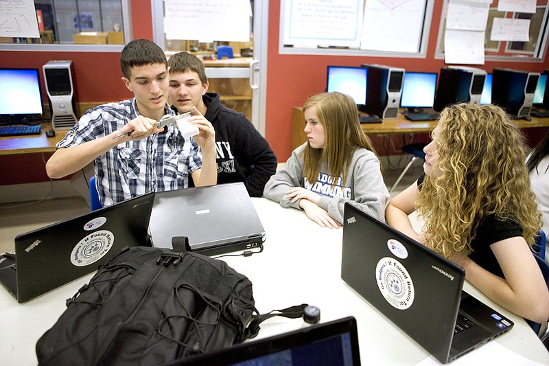 From the left, Andrew Diehl and Colby Bagwell measure a bar of soap while Katy Dickerson and Madeline Wallace record  the measurements. The group, in Arkadelphia High School’s New Tech program, is creating a digital model of the soap.