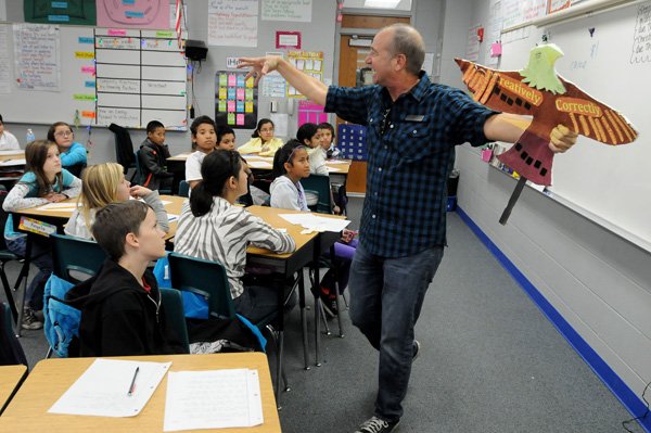 Clayton Scott, poet laureate of Fayetteville, uses props Tuesday to help teach Cori Fryar’s fifth-grade class at Lee Elementary School in Springdale. Scott taught the children about poetry and creative writing. 