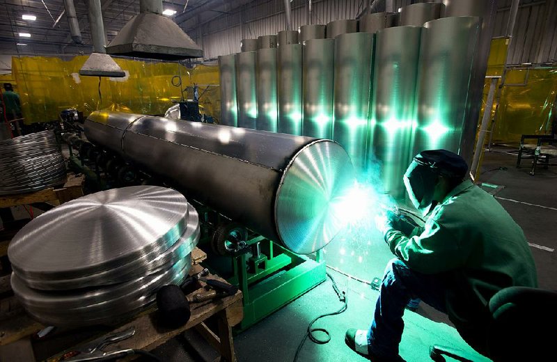 An employee of Nautic Global Group welds an end cap onto an aluminum pontoon at a factory in Elkhart, Ind., on Tuesday. Orders in October for business equipment such as machinery and communications gear rose more than previously estimated, the Commerce Department said. 