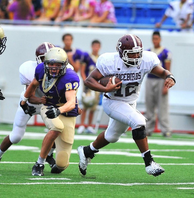 Stuttgart quarterback Dontrell Brown (right) runs through the CAC defense for a first down during the third quarter of Monday night's Kick Off Classic at War Memorial Stadium in Little Rock.
