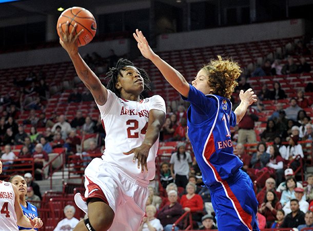 NWA Media/MICHAEL WOODS --12/06/2012-- Arkansas forward Quistelle Williams drives past Kansas defender Monica Engelman to score on a fast break during the first half of Thursday night's game at Bud Walton Arena in Fayetteville.