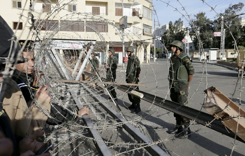 Egyptian army soldiers deploy outside the presidential palace, background right, in Cairo, Egypt, on Thursday, Dec. 6, 2012. 