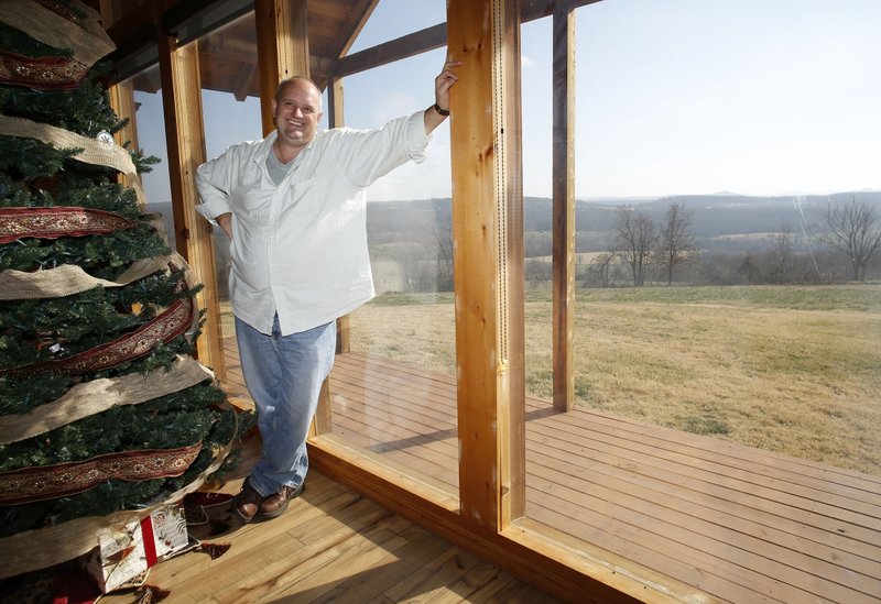 Chris Stecklein in his favorite personal space, the living room of his family's log cabin home in Madison County with a large south facing window.