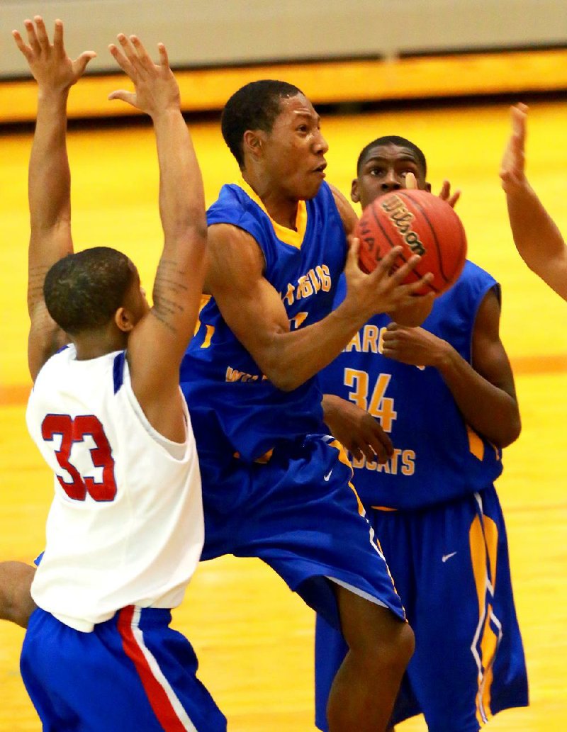 North Little Rock’s Kevaughn Allen (middle) drives to the basket against Little Rock Parkview’s Anton Beard (33) during the Charging Wildcats’ 82-68 victory over the Patriots in the Jammin’ for Jackets tournament Thursday in Little Rock. 