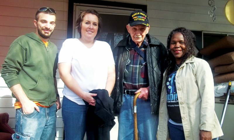 Herbert “Lucky” Page, a World War II veteran, stands on the porch of the home he shares with his wife, Monnie, on Lake Conway. Volunteers working to renovate the home include, from the left, Hendrix students Eric Monroe, Kaily Kilcrease and Shenel Sandidge, executive director of Habitat for Humanity of Faulkner County. The nonprofit organization is partnering with Home Depot of Conway and community volunteers on the project.