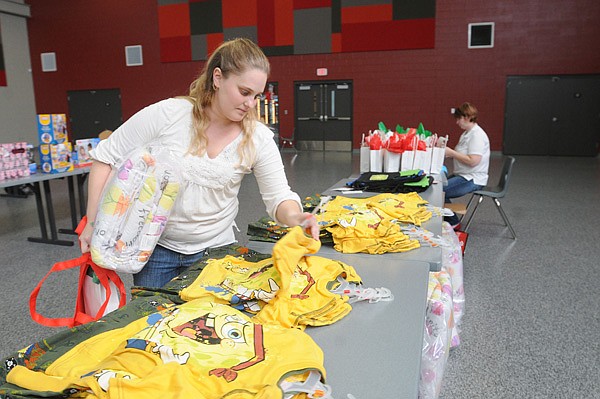 Sarah Senty selects a gift item Thursday during Operation Homefront’s workshop at the Armed Forces Reserve building in Vaughn. Carol Herrick, Operation Homefront executive director, is at right. 