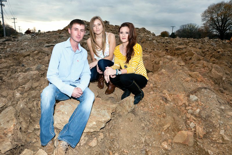 Former Julia Lee Moore Elementary School students, from the left, Talon Houston, Tori Cline and Amanda Brewer, all of Conway, gather at what is left of Scorpion Hill, a childhood hangout for students through the years. The former secluded area northeast of the school at Country Club Road and Tyler Street has been leveled.