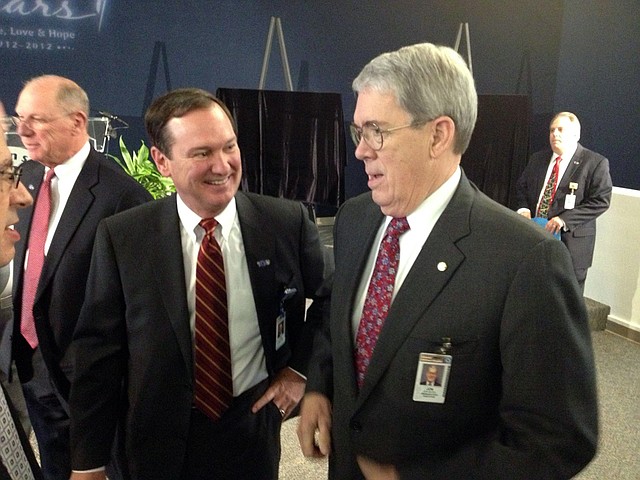 Dr. Jonathan R. Bates, right, visits with supporters before a news conference Friday. Bates will retire at the end of June after 20 years leading the hospital, according to information made available before a news conference Friday morning.