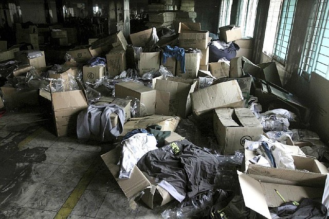 Boxes of garments lay near equipment charred in a Nov. 24 fire that killed 112 workers at the Tazreen Fashions factory on the outskirts of Dhaka, Bangladesh. 