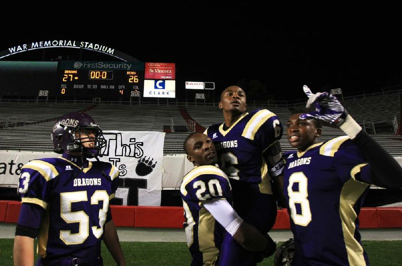 Dorian Evans (6) gets a celebratory boost from Sam Williams (20) as Randall Holleyfield enjoys the moment after Evans’ 30-yard touchdown catch gave Junction City the Class 2A title Friday night. 