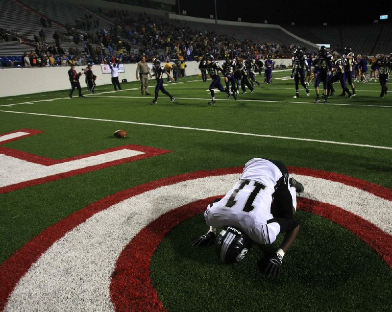Bearden’s Daniel Williams sprawls out in the end zone as Junction City players celebrate following Dorian Evans’ game-winning 30-yard touchdown catch on the final play of Friday night’s Class 2A state championship game at War Memorial Stadium in Little Rock. 