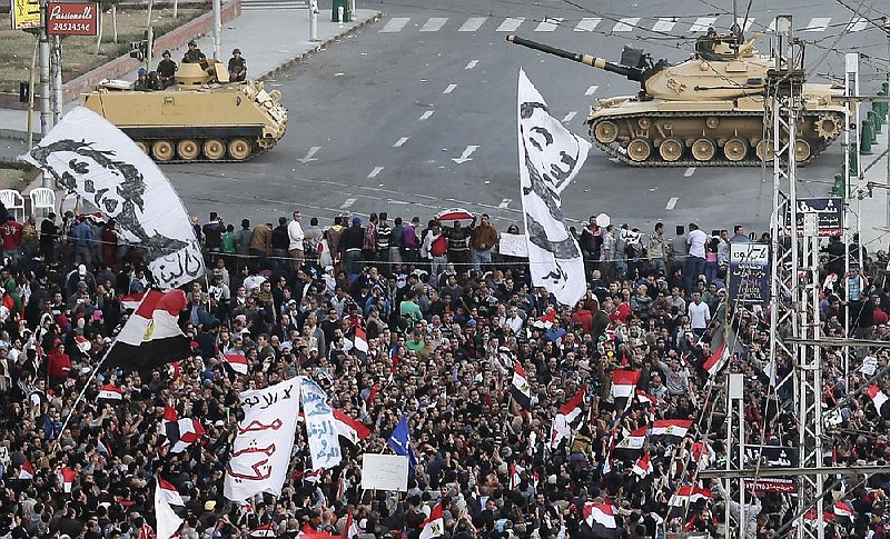 With tanks guarding the perimeter, protesters gather Friday near Egyptian President Mohammed Morsi’s presidential palace. Opposition leaders have called for an ongoing sit-in at the palace. 