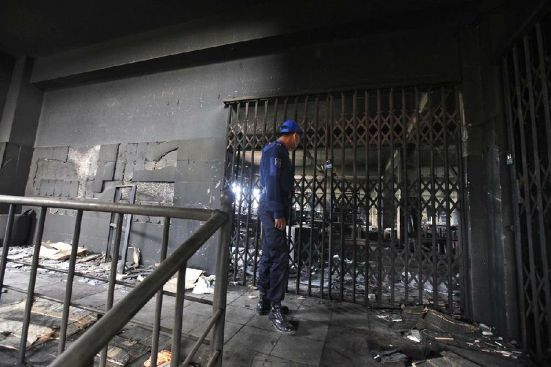 A Bangladeshi policeman stands inside the fire-damaged Tazreen garment factory on the outskirts of Dhaka on Friday. 