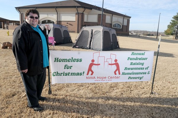 Everett Coonfield stands outside his tents Thursday on the lawn of First Assembly of God in Springdale. Coonfield planned to sleep outdoors for three nights to simulate the homeless experience and raise money and awareness for his nonprofit organization, NWA Hope Center. Coonfield was homeless himself and is dedicated to bringing relief to homeless people. He hopes to raise $10,000 with this year’s efforts. 