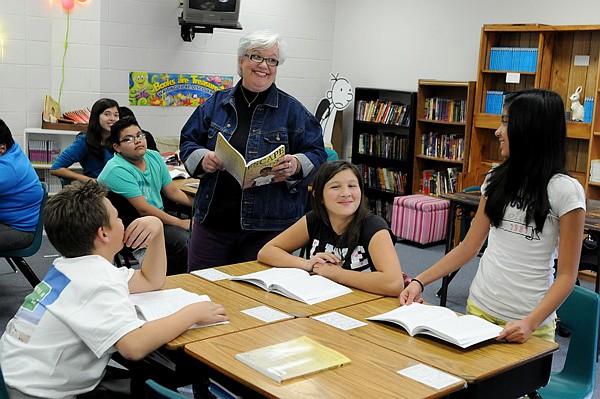 Missy Allgood, a sixth-grade language-arts teacher at Helen Tyson Middle School in Springdale, laughs with Maria Pineda on Thursday as they discuss the novel Escape from Saigon: How a Vietnam War Orphan Became an American Boy. Allgood is one of several teachers who have combined reading and writing in the classroom to get students to understand and write about what they read. 