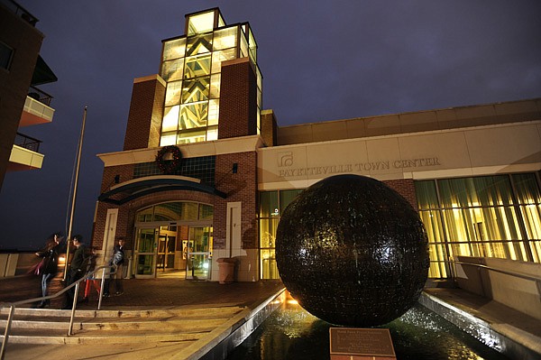 Visitors exit the Fayetteville Town Center on Friday on the Fayetteville square. 