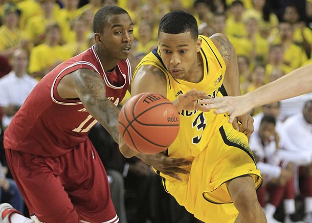 Arkansas guard BJ Young (11) reaches in and fouls Michigan guard Trey Burke (3)during the second half of an NCAA college basketball game in Ann Arbor, Mich., Saturday, Dec. 8, 2012. (AP Photo/Carlos Osorio)