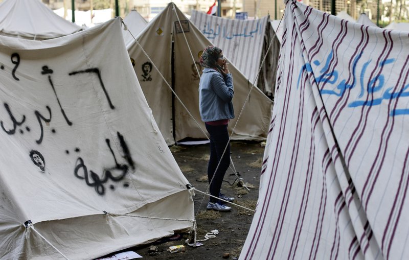 An Egyptian protester smokes a cigarette outside her tent in Tahrir square in Cairo, Egypt, Sunday, Dec. 9, 2012. Egypt's liberal opposition has called for more protests on Sunday after the president made concessions overnight that fell short of their demands to rescind a draft constitution going to a referendum on Dec. 15.