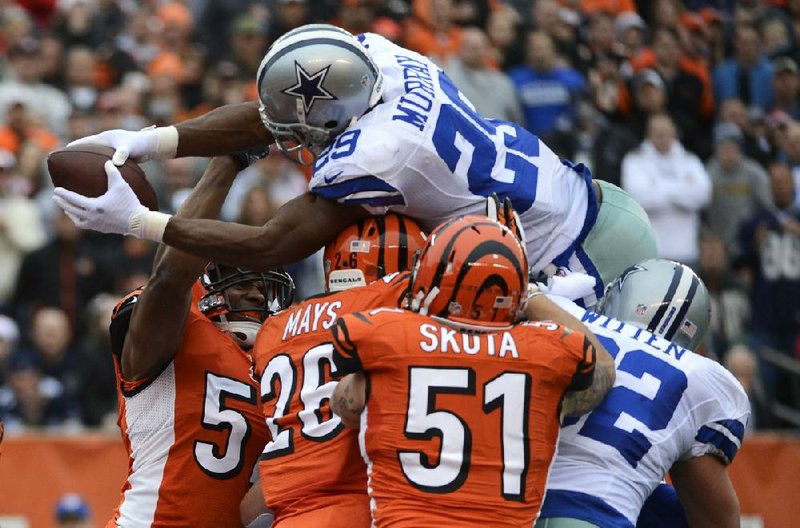 Dallas running back DeMarco Murray (29) dives over the Cincinnati Bengals defense from 1 yard out to score a second-quarter touchdown in Sunday’s game. Murray’s touchdown tied the game at 10-10, but the Cowboys needed 10 points in the final 6:35 to pull out a 20-19 victory. 