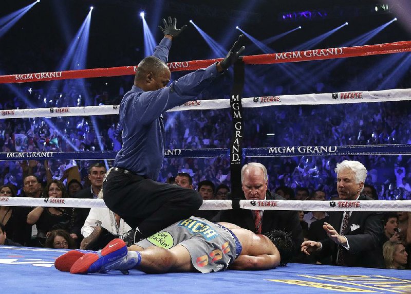Manny Pacquiao finished his fourth fight with Juan Manuel Marquez face down on the canvas in Las Vegas. Referee Kenny Bayless (left) counted Pacquiao out after Marquez blasted his rival with a right hand with one second left in the sixth round. 